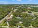 Aerial view of a neighborhood with lush trees, green lawns, and nearby roads at 520 Lafayette Blvd, Oldsmar, FL 34677