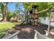 Backyard featuring a wooden playset, a charming outbuilding, and Adirondack chairs for relaxation under the trees at 520 Lafayette Blvd, Oldsmar, FL 34677