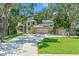 Charming home with mature trees, brick accents, solar panels and lush lawns on a sunny day at 520 Lafayette Blvd, Oldsmar, FL 34677