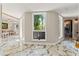 Hallway features marble floors, bright windows, and neutral decor and views into other rooms at 520 Lafayette Blvd, Oldsmar, FL 34677