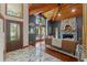 Living room with stone fireplace, wooden ceiling, large windows and a decorative entry door at 520 Lafayette Blvd, Oldsmar, FL 34677