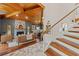 Comfortable living room featuring hardwood floors, stone fireplace, wood ceiling, and modern staircase at 520 Lafayette Blvd, Oldsmar, FL 34677