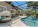 Relaxing screened-in pool area with stone pavers, comfortable seating, and a tranquil waterfall feature at 520 Lafayette Blvd, Oldsmar, FL 34677