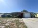 Charming single-story home featuring a red front door and attached garage on a sunny day at 5316 Drift Tide Dr, New Port Richey, FL 34652