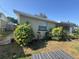The side of the home featuring well-maintained landscaping with lush bushes and garden at 5316 Drift Tide Dr, New Port Richey, FL 34652