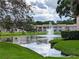 Scenic pond with a fountain surrounded by lush green grass and trees, offering a serene view at 6410 Spring Flower Dr # 26, New Port Richey, FL 34653