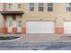 Tan two-story townhouse with a white garage door and nicely landscaped front at 658 Siren Wind Ln, Clearwater, FL 33756