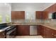 Kitchen with granite countertops, stainless appliances, and dark wood cabinets at 658 Siren Wind Ln, Clearwater, FL 33756