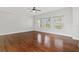 Living room with wood floors, three windows, and a ceiling fan at 658 Siren Wind Ln, Clearwater, FL 33756