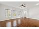 Bedroom with wood floors, three windows, and a ceiling fan at 658 Siren Wind Ln, Clearwater, FL 33756