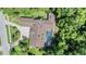 Aerial view of a home with a screened pool, paved driveway, and mature trees at 663 Turnberry Ct, Tarpon Springs, FL 34688