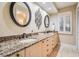 Elegant bathroom with granite countertops, double sinks, and decorative mirrors at 663 Turnberry Ct, Tarpon Springs, FL 34688