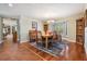 Bright dining room featuring wood floors, a bay window with shutters, and a wooden table with seating for six at 663 Turnberry Ct, Tarpon Springs, FL 34688