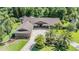 Spacious home with lush landscaping, mature palm trees, and paver driveway at 663 Turnberry Ct, Tarpon Springs, FL 34688