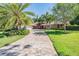 Attractive single-Gathering home with a paved driveway and lush tropical landscaping at 663 Turnberry Ct, Tarpon Springs, FL 34688