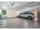 Well-lit garage featuring epoxy floors, built-in cabinets, a car, and a window at 663 Turnberry Ct, Tarpon Springs, FL 34688