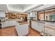 Bright kitchen featuring stone counters, white cabinets, stainless steel appliances and a center island at 663 Turnberry Ct, Tarpon Springs, FL 34688