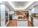 Spacious kitchen features stone counters, stainless steel appliances, and an island with an electric cooktop at 663 Turnberry Ct, Tarpon Springs, FL 34688