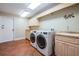 Spacious laundry room with washer, dryer, sink, cabinets, and tile flooring at 663 Turnberry Ct, Tarpon Springs, FL 34688