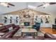 Spacious living room featuring a stone fireplace, built-in shelving, ceiling fans, and comfortable seating at 663 Turnberry Ct, Tarpon Springs, FL 34688