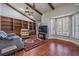 Spacious living room includes wood beams, a ceiling fan, built-in shelves and plenty of natural light at 663 Turnberry Ct, Tarpon Springs, FL 34688