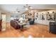 Bright living room showcasing a stone fireplace, built-in shelving, ceiling fans, and wood flooring at 663 Turnberry Ct, Tarpon Springs, FL 34688