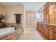 Main bathroom featuring a vanity, large tub with tile surround and shutters on the window at 663 Turnberry Ct, Tarpon Springs, FL 34688