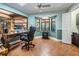 Office space with a bay window, tile floors, and a view of the screened lanai and pool area at 663 Turnberry Ct, Tarpon Springs, FL 34688