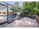 Screened-in pool area with a deck and outdoor seating amidst lush greenery at 663 Turnberry Ct, Tarpon Springs, FL 34688