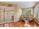 Relaxing sitting room featuring hardwood floors, comfortable chairs and shutters on windows and doors at 663 Turnberry Ct, Tarpon Springs, FL 34688