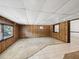 Spacious basement featuring wood-paneled walls, tiled flooring, and cozy carpet at 7012 Ponderosa Dr, Tampa, FL 33637