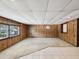 Finished basement featuring carpet, tiled flooring, wood-paneled walls and windows at 7012 Ponderosa Dr, Tampa, FL 33637