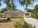 Welcoming single-story home with a concrete driveway and a cozy, well-lit entryway at 7012 Ponderosa Dr, Tampa, FL 33637