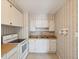 Functional kitchen area featuring laminate counters, white appliances, and vintage wallpaper at 7012 Ponderosa Dr, Tampa, FL 33637