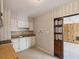 Cozy kitchen featuring vintage wallpaper, clean white cabinets, and tile flooring at 7012 Ponderosa Dr, Tampa, FL 33637