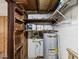 A well-lit utility room featuring a hot water heater and storage shelves at 7012 Ponderosa Dr, Tampa, FL 33637