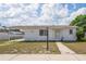 Charming single-story home with a covered carport, neatly kept lawn, and neutral color scheme at 7050 Merrick Ln, Spring Hill, FL 34606