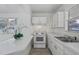 Bright kitchen features white appliances, cabinets, and a breakfast bar, creating a clean, modern aesthetic at 7050 Merrick Ln, Spring Hill, FL 34606