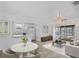 Bright living room featuring tile flooring, a ceiling fan, and sliding glass doors to the screened porch at 7050 Merrick Ln, Spring Hill, FL 34606