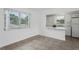 Tile flooring spans a bright living area, connecting to an adjacent kitchen with a breakfast bar, enhancing open-concept living at 7050 Merrick Ln, Spring Hill, FL 34606