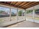 Enclosed sunroom with ample windows offers serene views of the backyard, perfect for relaxation or entertaining at 7050 Merrick Ln, Spring Hill, FL 34606