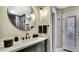 Modern bathroom boasts a large round mirror over a stylish dark vanity with sleek fixtures at 7233 Royal Oak Dr, Spring Hill, FL 34607