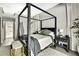 Stylish primary bedroom featuring a striking four-poster bed and ensuite access at 7233 Royal Oak Dr, Spring Hill, FL 34607