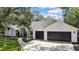Traditional home with a two-car garage and lush landscaping at 7233 Royal Oak Dr, Spring Hill, FL 34607
