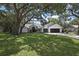 Traditional home showcasing a well-manicured lawn and mature trees, creating an inviting curb appeal at 7233 Royal Oak Dr, Spring Hill, FL 34607