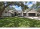 The traditional home boasts a pristine lawn, lush trees and a two-car garage at 7233 Royal Oak Dr, Spring Hill, FL 34607