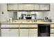 Kitchen with white cabinetry looks into open floorplan living room at 7233 Royal Oak Dr, Spring Hill, FL 34607