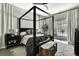 Main bedroom with modern canopy bed and access to lanai at 7233 Royal Oak Dr, Spring Hill, FL 34607