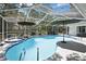 Screened-in pool with a jacuzzi and umbrella providing shade to the pool and patio furniture at 7233 Royal Oak Dr, Spring Hill, FL 34607
