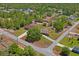 Aerial view of two homes with green lawns, mature trees, and a quiet street at 7270 Nightwalker Rd, Weeki Wachee, FL 34613
